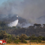 A firefighting helicopter battles the blaze in the Les Gavarres mountain range in Catalonia, with fire crews securing the ground below./ Photo: Social media